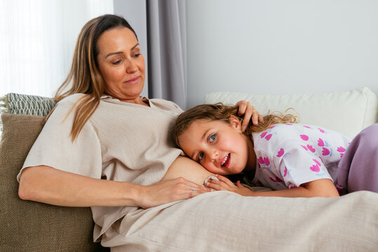 Little cute girl istening pregnant mother's belly.