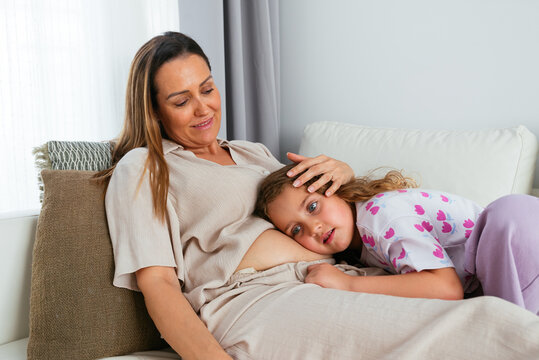 Little cute girl istening pregnant mother's belly.