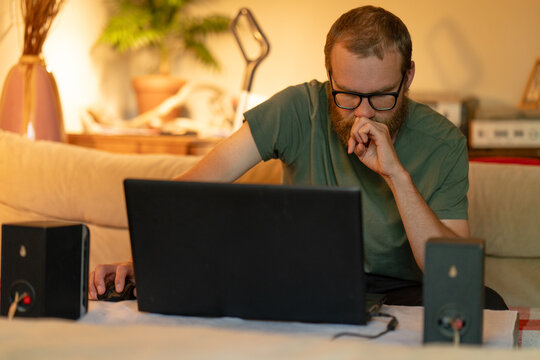 Man Working on Laptop at Home in Evening