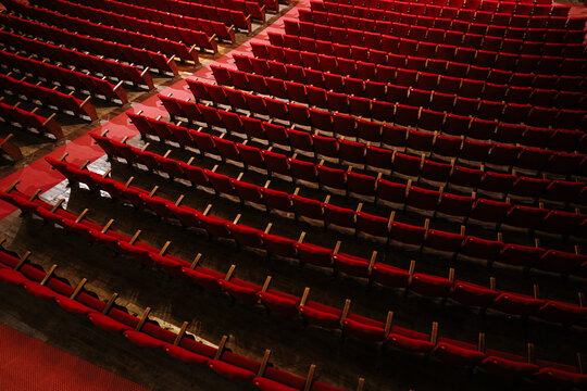 Rows of empty red velvet seats filling an auditorium