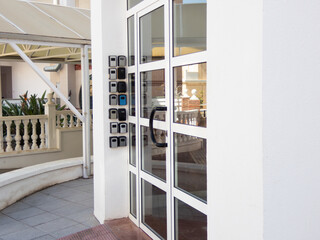 Modern building entrance with multiple key lock boxes and glass door