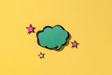 Green speech bubble with stars against a bright yellow background