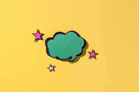 Green speech bubble with stars against a bright yellow background