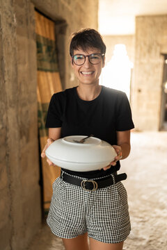 Chef holding covered dish smiling in Senegal, Africa