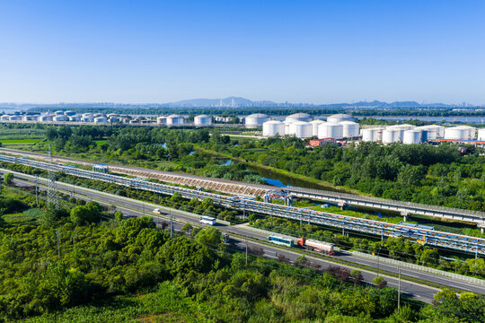 oil storage tanks with pipelines and highway in industrial zone