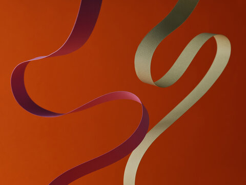 Abstract ribbons dance across an orange background