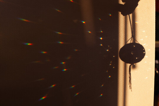 Rainbow light reflections and shadow on wall
