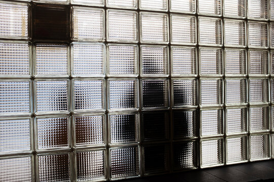 Modern glass wall with reflections and shadows of humans in city