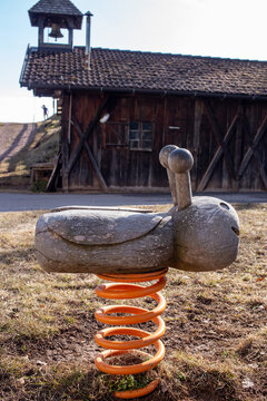 Children's seesaw in front of a barn