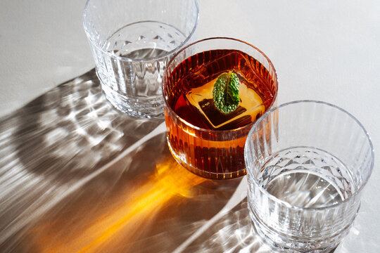 Amber cocktail with mint and empty glasses