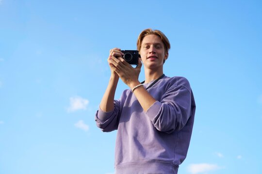 Young Man Taking Pictures Outdoors During Sunny Day