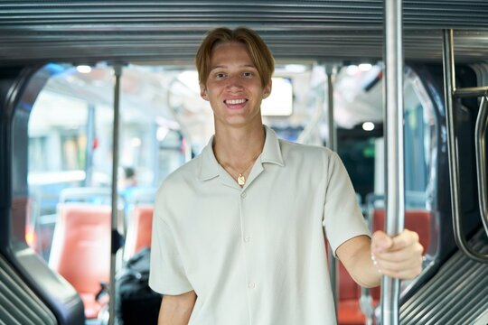 Young Man Enjoys the Ride on a City Bus During Daytime Commute