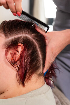 Hairdresser combing client's hair
