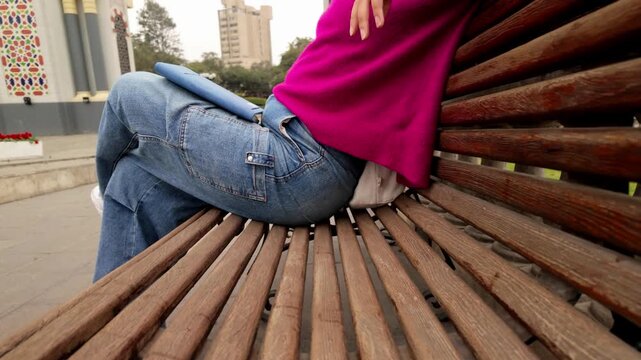 Relaxed young woman listening to music on a park bench