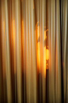 Orange curtain with stripes in front of a window