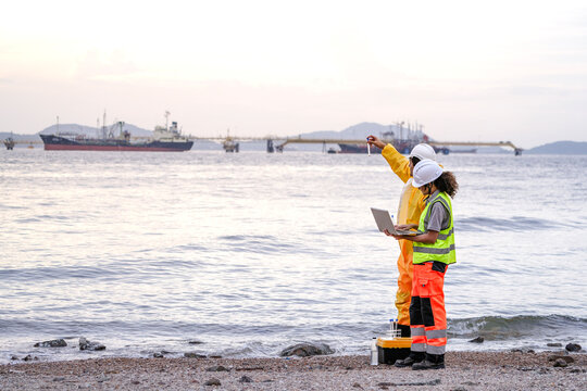 Two field scientists in PPE gear analyzing seawater samples using test tubes and a laptop. Environmental monitoring and pollution control on the coastline are depicted.