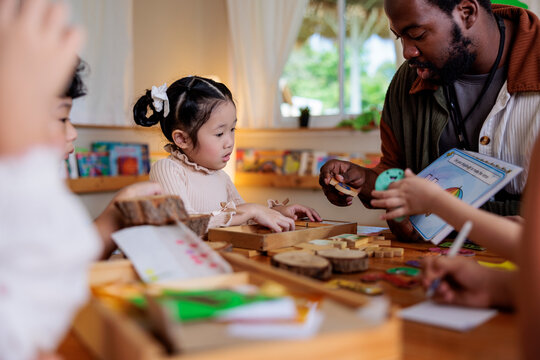 Teacher helps children with puzzles and learning activities.