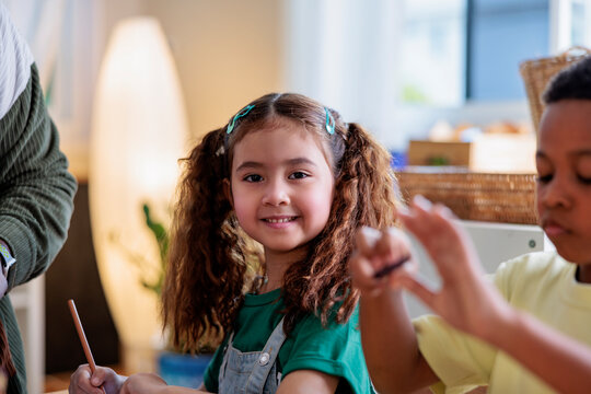 Smiling girl with pigtails at art class.
