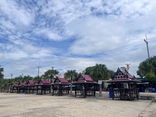 Row of Thai Pavilions Under Cloudy Sky