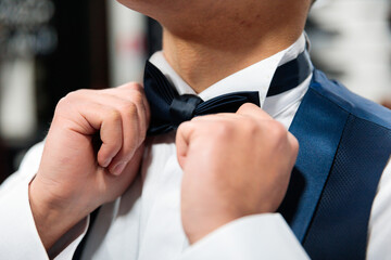 Close-up of hands fixing a bow tie
