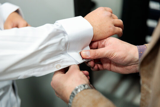 Vendor adjusting client&rsquo;s cuff during fitting