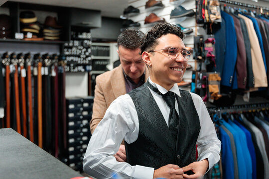Smiling man getting fitted for a tailored suit vest