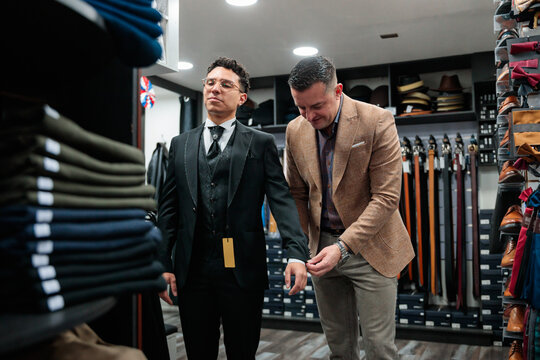 Salesman giving assistance to a latin customer in clothing store