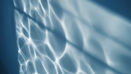 Abstract and elegant reflections of light and shadow create a serene, rippled effect. This image evokes tranquility