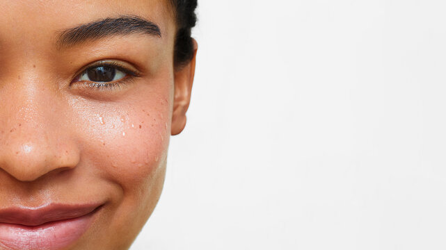 Smiling Latina woman with water droplets on her skin 