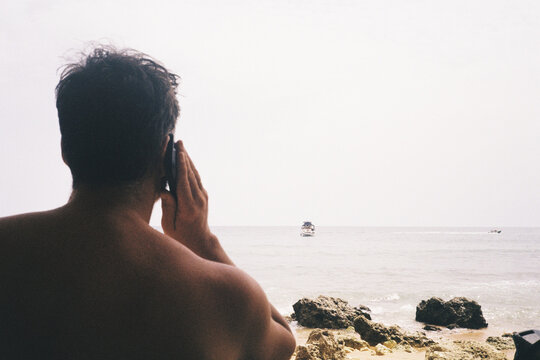 Man calling boat captain at beach