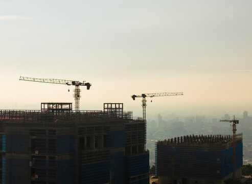 City Construction Site with Cranes at Sunrise.