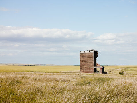 Abandoned wooden grain elevator in prairie field