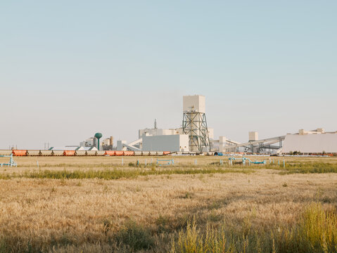 Potash plant and freight train across prairie farmland