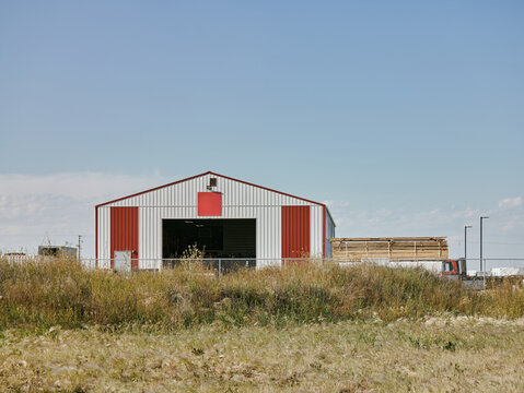 Red and white warehouse with stacked lumber