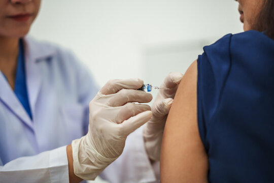 doctor holding syringe and making injection vaccine to patient
