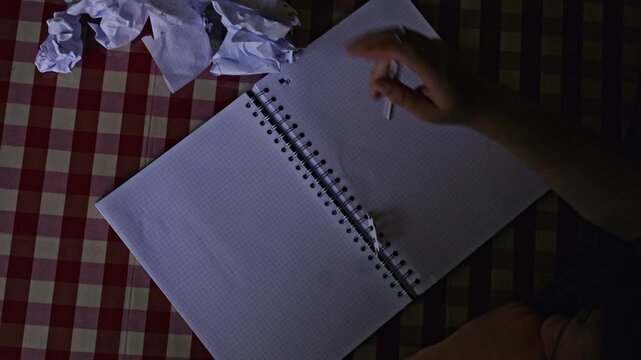 A student grapples with a challenging math problem, showing frustration by crumpling paper before rededicating to the task. This scene captures the struggle of learning and academic pressure.