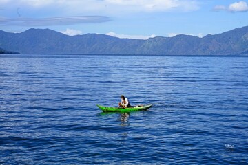 A wooden boat is sailing on a lake with beautiful scenery