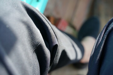 Legs wearing long black pants and black shoes with blurred background