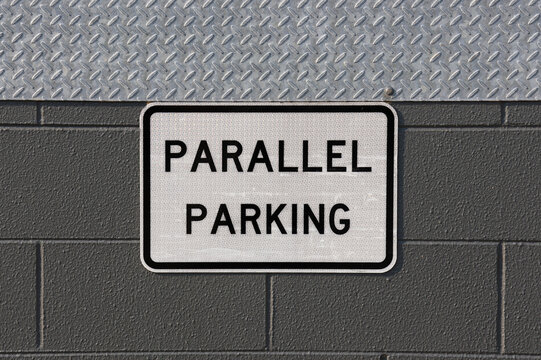 Parallel Parking sign attached to a wall with a metallic diamond plate and grey gray concrete blocks