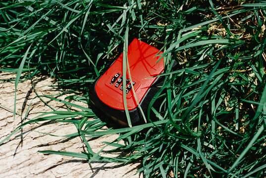 a red combination key lockbox hidden in grass, 35mm film