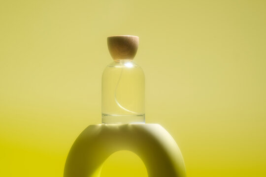 Elegant fragrance bottle with wooden cap displayed on a curved
