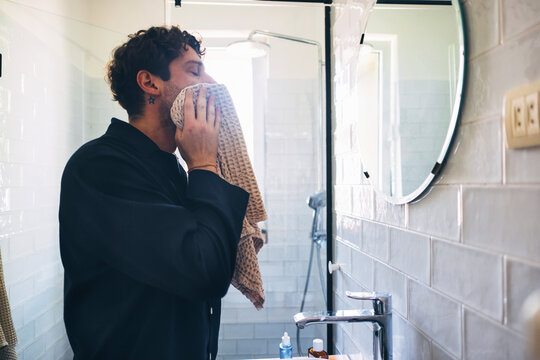 Man Drying Face in Modern Bathroom After Fresh Morning Routine