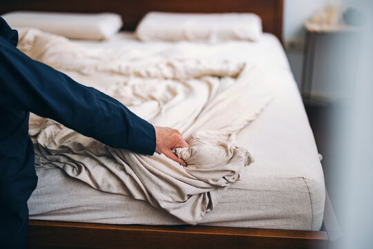 Person Adjusting Wrinkled Bedsheet 