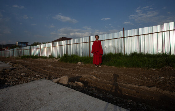 In the red outfit at metal fence 
