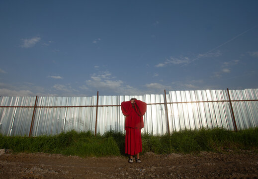 In the red outfit at metal fence 