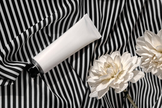 Blank Cream Tube and White Chrysanthemums on Striped Cloth. 