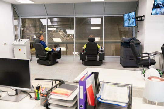 Control Room With Operators Monitoring Machinery 