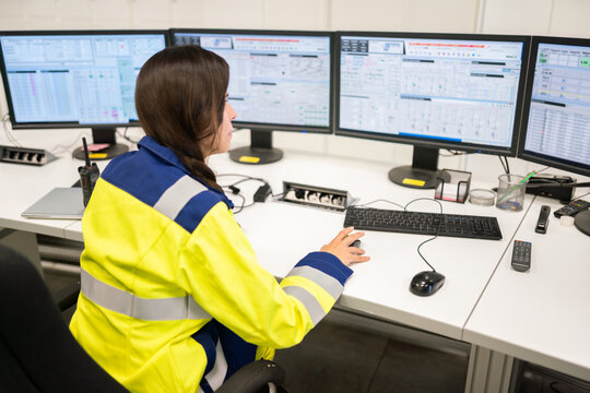Professional Worker Monitoring Data on Multiple Computer Screens