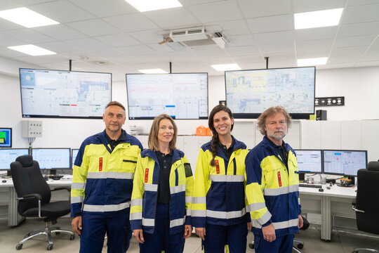 Team of Professionals in Safety Gear in a Control Room
