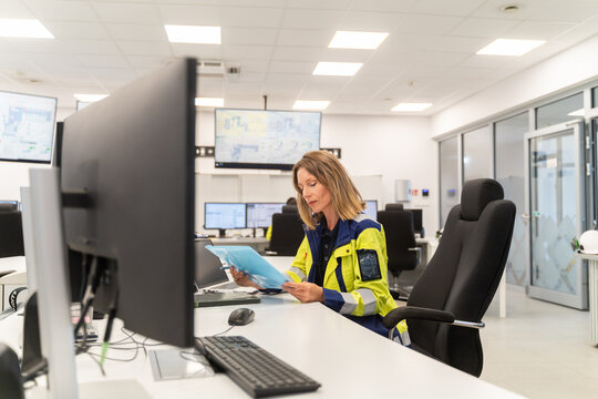 Operator Inspecting Documents in a Control Room